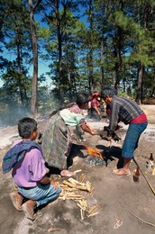 Man and woman sacrificing a chicken over a fire during pagan worship at Pascual Abaj, Chichicastenango, Guatemala, Central America