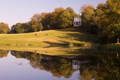 A Gothic folly reflected in the lake at Painshill Landscape Garden, Cobham, Surrey, England, United Kingdom, Europe