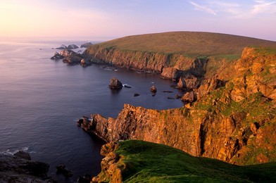 Cliffs of Hermaness Nature Reserve, looking north towards Vesta Skerry, Tipta Skerry gannetry, Muckle Flugga and its lighthouse in the distance, Unst, Shetland, Scotland, United Kingdom, Europe