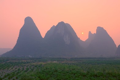 Karst landscape and setting sun, Yangshuo, Guangxi Province, China, Asia