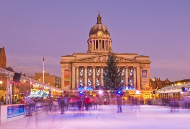 Ice skaters on the temporary Christmas outdoor ice skating rink in the Old Market Square in front of the Council House in the city centre, Nottingham, Nottinghamshire, England, United Kingdom, Europe