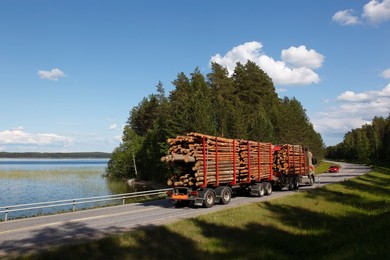 Truck transporting timber beside Lake Puruvesi, Punkaharju Nature Reserve, Saimaa Lake District, Savonia, Finland, Scandinavia