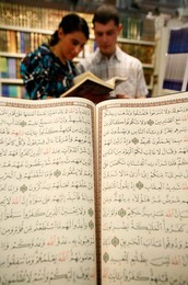 Couple reading the Koran at U.O.I.F. annual meeting, Paris, France, Europe