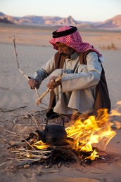 Bedouin making tea on open fire in the desert of Wadi Rum, Jordan, Middle East