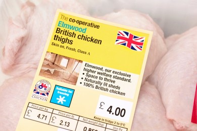 Pack of Co-operative Elmwood British chicken thighs sourced from high standard farms with signs / logos of British farm standard logo from the assured food standards association of the little red tractor symbol & the Britsh union jack