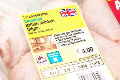 Pack of Co-operative Elmwood British chicken thighs sourced from high standard farms with signs / logos of British farm standard logo from the assured food standards association of the little red tractor symbol & the Britsh union jack