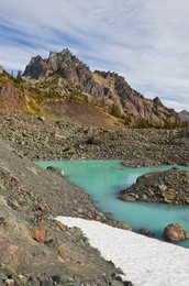 Tarn colored aqua by glacial flour in the cirque of Royal Basin, looking toward Mt. Clark and The Needles, in Olympic National Park, Washington State, USA.