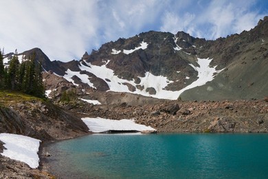 Imperial Tarn with its colorful aqua tint due to glacial flour, looking toward Mt. Deception, in the cirque of Royal Basin in Olympic National Park, Washington State, USA.