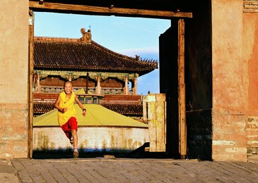 A Mongolian Buddhist Monk running through monastery