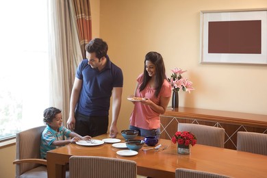 Parents serving food to son at dinning table