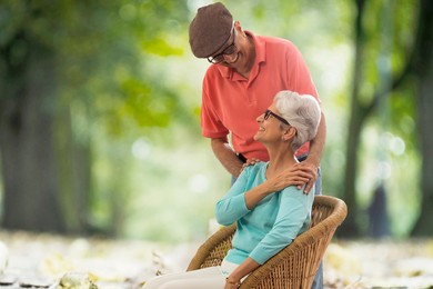 Senior couple enjoying nature outdoors sitting  on wicker chair
