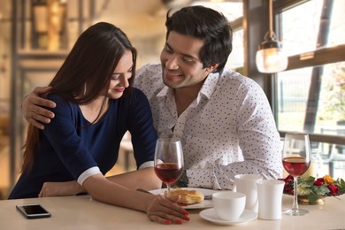Happy young couple having food at restaurant table