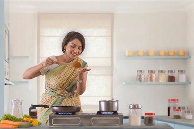 woman tasting food on hand while preparing it