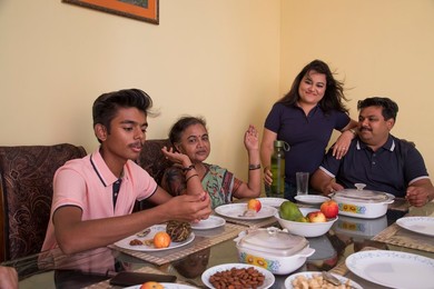 Happy family sitting around the dining table at home.