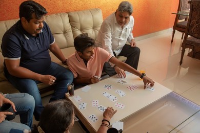 Happy family playing with cards in the living room at home.
