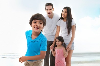 Portrait of happy family on sunny beach
