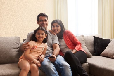 Happy family watching TV at home