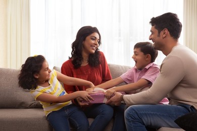 Happy family of four snatching a gift box