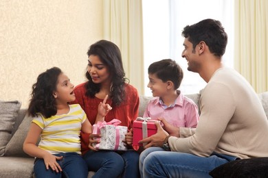 Happy family of four holding a gift box