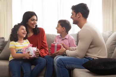 Happy family of four holding a gift box