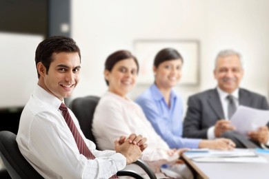 Successful businessman smiling with executives in a meeting