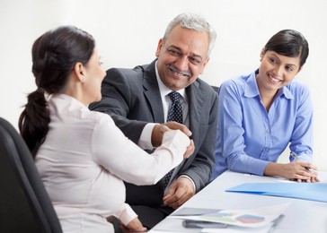 Smiling business people shaking hands in meeting