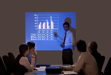 Businessman giving graph presentation to executives in meeting