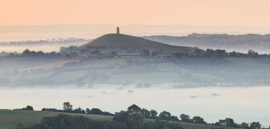 Glastonbury Tor rising above a misty landscape on an autumn morning, Somerset, England, United Kingdom