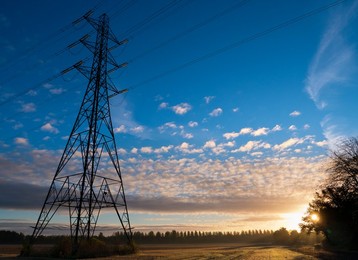 Giant pylon in a field in Radley Village, Autumn sunrise with dramatic sky