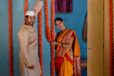 Maharashtrian couple decorating house on festival