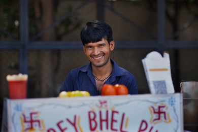 Portrait of a smiling male street vendor looking at camera
