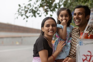 Portrait of happy family standing near street shop
