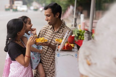 Portrait of happy family eating bhelpuri