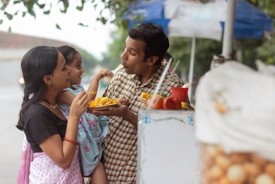 Portrait of happy family eating bhelpuri