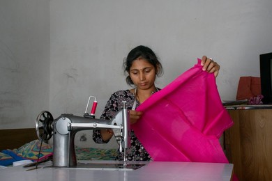 woman working on sewing machine as tailor