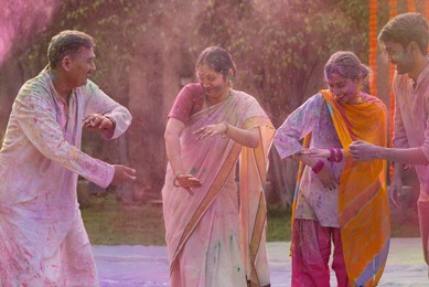 Happy Indian family dancing together on the occasion of Holi