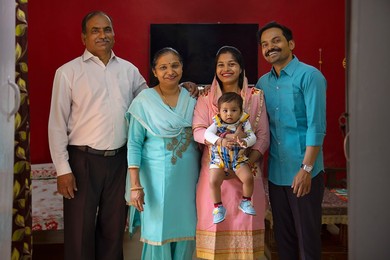 Portrait of happy Indian family members standing together at home