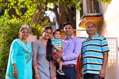 Portrait of happy family members standing in front of gate