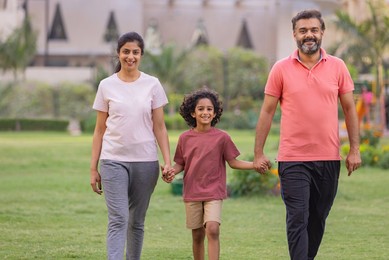 Portrait of happy family walking together in the park