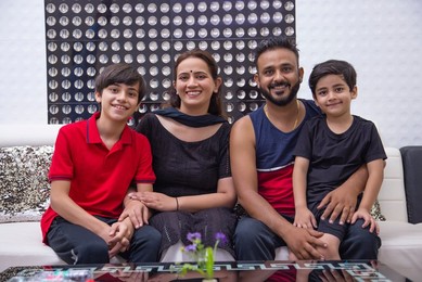 Happy family sitting together in living room at home