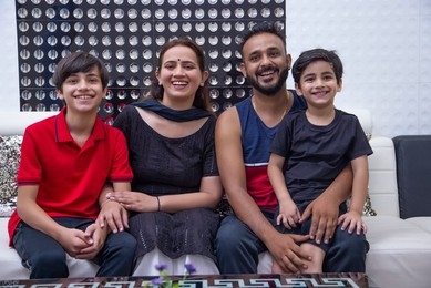 Happy family sitting together in living room at home