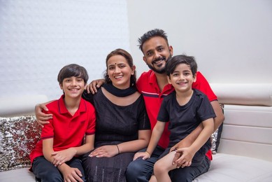 Happy family sitting together in living room at home