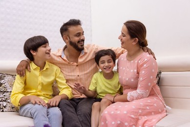 Happy family sitting together on sofa at home
