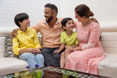 Happy family sitting together on sofa at home