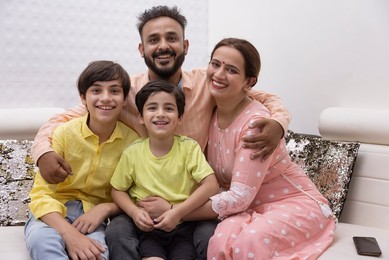 Happy family sitting together on sofa at home
