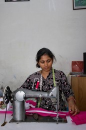 woman working on sewing machine as tailor