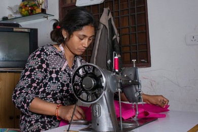 woman working on sewing machine as tailor