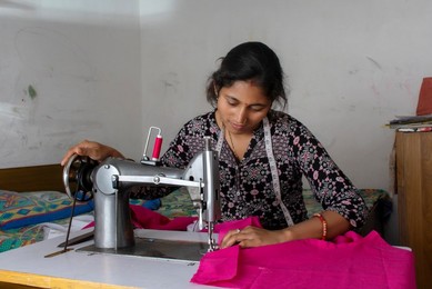woman working on sewing machine as tailor