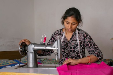 woman working on sewing machine as tailor