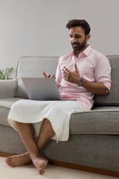 Man working from home and attending an office meeting on video call